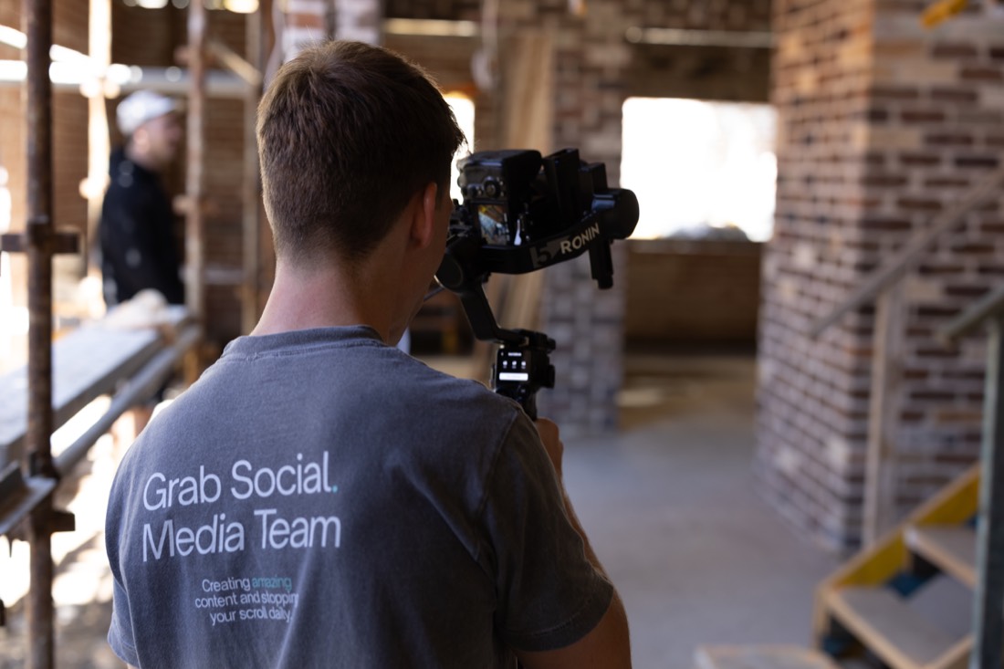 A videographer filming on a building site